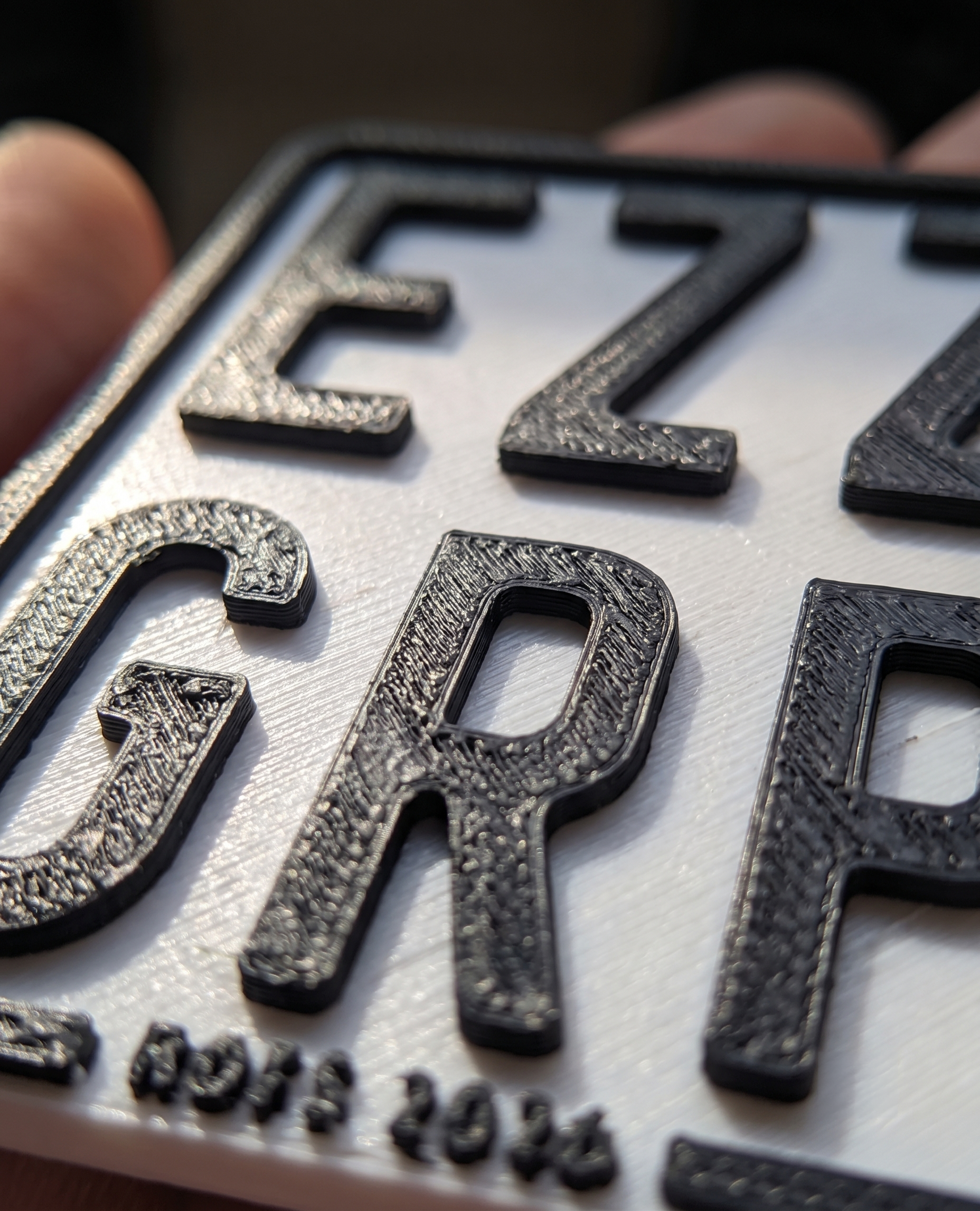 Nahaufnahme der erhabenen 3D-Druck-Schrift auf dem Deko-Kennzeichen